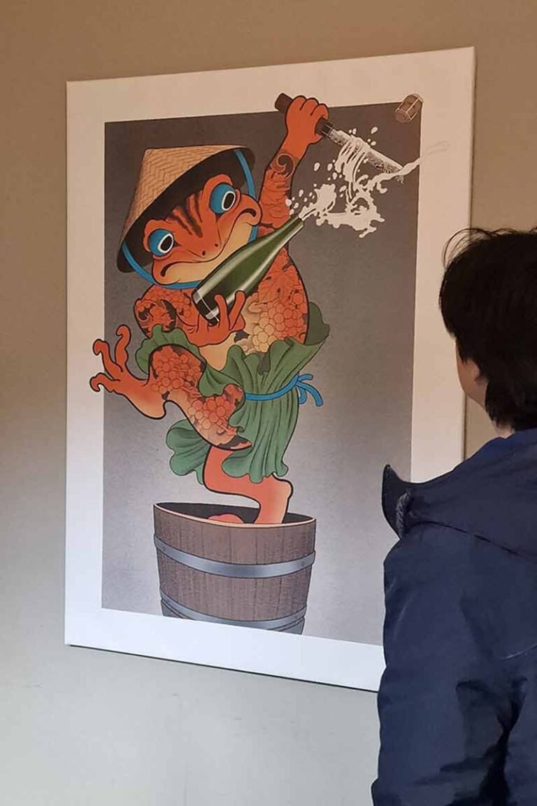 Student observing Japanese-inspired frog artwork by Kaspar Schumacher at Konomi Festival Basel.